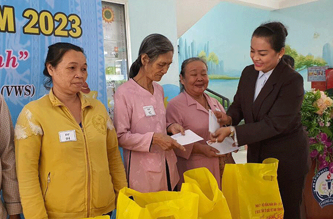 Bà Trương Thị Ngọc Hằng, Giám đốc đối ngoại công ty VWS trao tặng quà cho người dân.