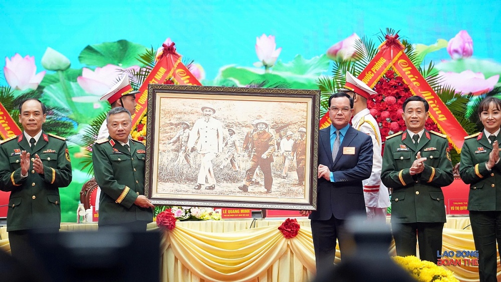 Đồng chí Nguyễn Đình Khang, Ủy viên Trung ương Đảng, Phó Chủ tịch Ủy ban Trung ương Mặt trận Tổ quốc Việt Nam, Chủ tịch Tổng Liên đoàn Lao động Việt Nam lên tặng hoa và bức tranh chúc mừng đoàn đại biểu. Ảnh: Mạnh Thắng