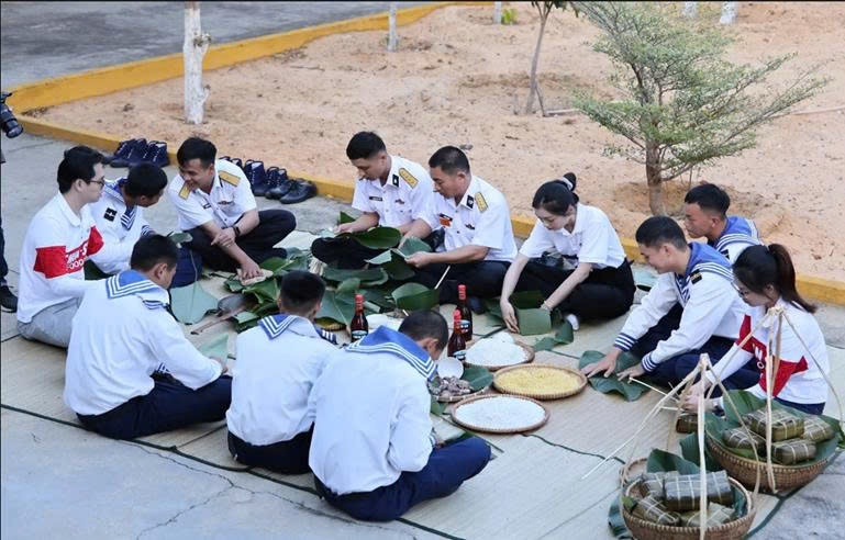 Các cán bộ, chiến sĩ và đoàn công tác cùng gói từng chiếc bánh chưng