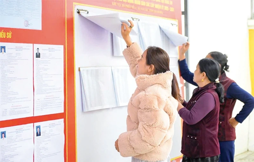 Cử tri xã Vạn Lộc xem danh sách cử tri niêm yết tại điểm bỏ phiếu.