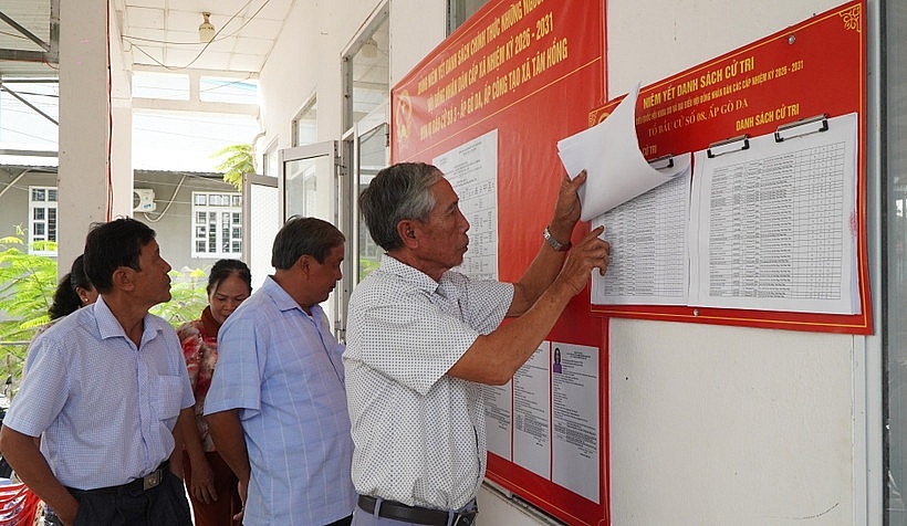 Người dân xem danh sách cử tri được niêm yết tại điểm bỏ phiếu. Ảnh: Nhựt An/TTXVN