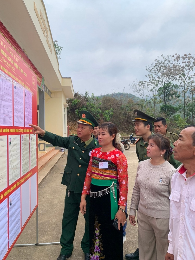 Cử tri thôn Đoàn Kết có mặt từ sớm để tranh thủ xem lại tiểu sử của các ứng cử viên trước khi bỏ phiếu