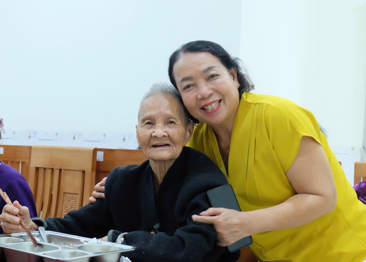 Cô Trần Thị Bộ hỏi thăm người cao tuổi trong bữa ăn trưa