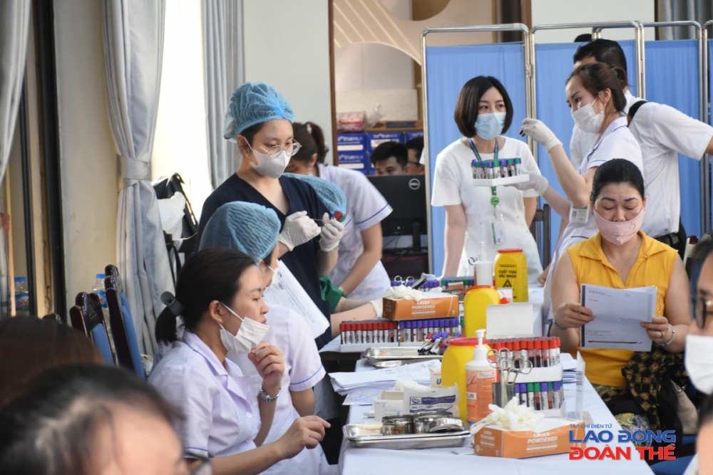 Các nhân viên y tế kiểm tra sức khoẻ cho người lao động. Ảnh: Nguyễn Việt