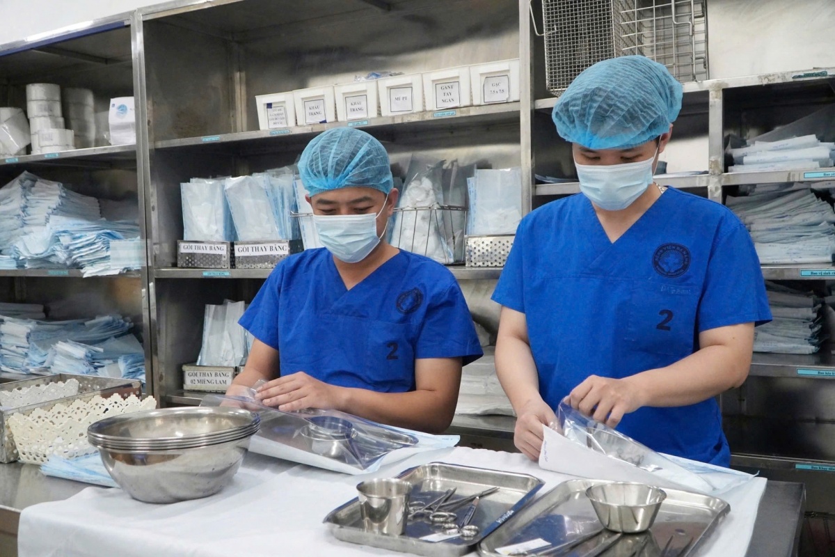Nhân viên kiểm soát nhiễm khuẩn đóng gói dụng cụ sau làm sạch, chuẩn bị tiệt khuẩn trước khi cấp phát cho các khoa lâm sàng. Ảnh: NAM BÌNH.