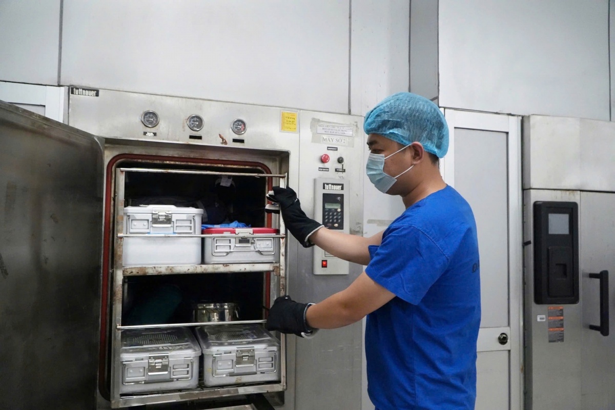 Nhân viên kiểm soát nhiễm khuẩn thực hiện tiệt khuẩn dụng cụ bằng phương pháp hấp nhiệt độ cao, góp phần bảo đảm môi trường điều trị an toàn cho bệnh nhân. Ảnh: NAM BÌNH.