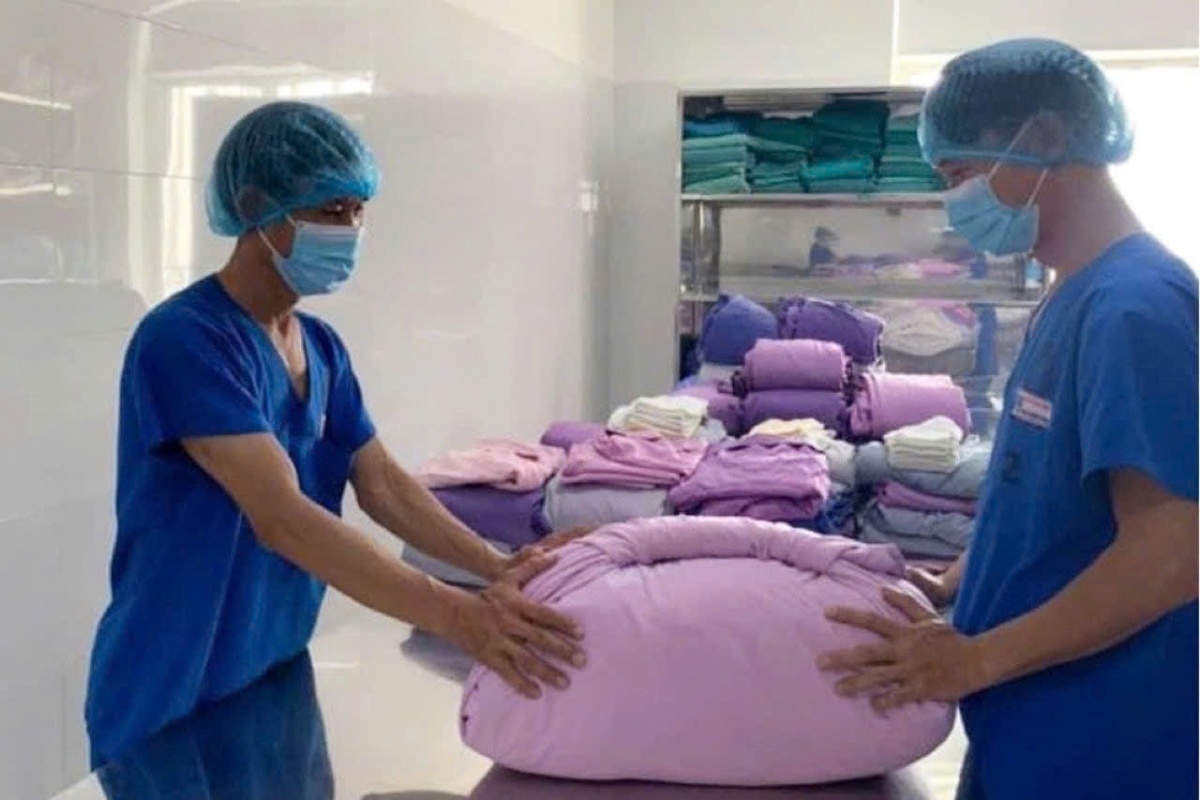 Đóng gói đồ vải phẫu thuật theo đúng tiêu chuẩn kỹ thuật và phương thức bao gói nhằm bảo đảm hiệu quả tiệt khuẩn và duy trì trạng thái vô khuẩn đến khi sử dụng cho các ca phẫu thuật. Ảnh: NAM BÌNH.