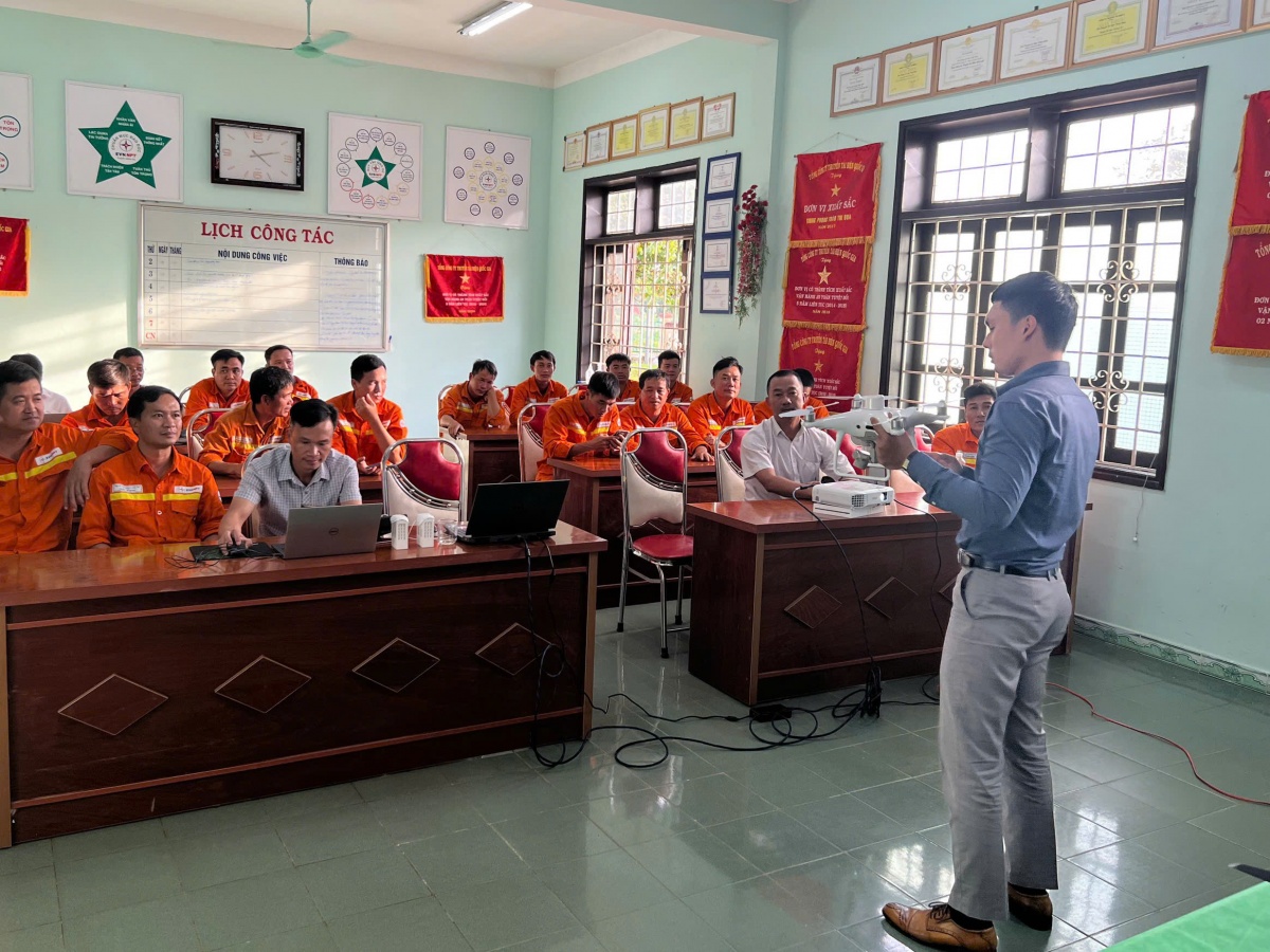 Kỹ sư Nguyễn Văn Vinh trao đổi về thiết bị không người lái với cán bộ, kĩ sư, người lao động của đơn vị. Ảnh: NVCC.