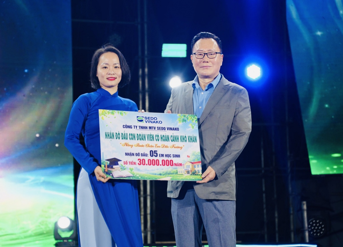 Ông Kim Byung Tae - Giám đốc Công ty TNHH MTV Sedo Vinako (bên phải) trao bảng ghi nhận đỡ đầu 5 em là con đoàn viên.