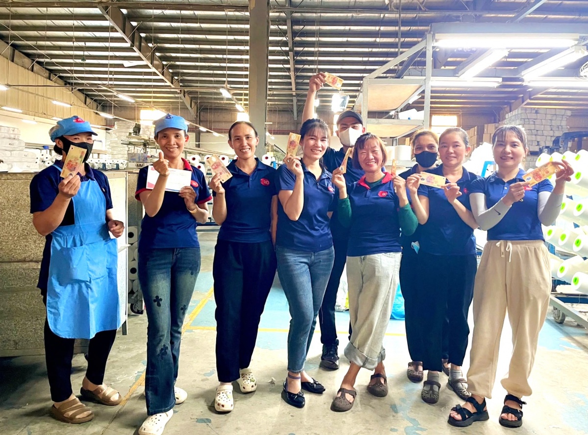 Công nhân Công ty TNHH Sản xuất sợi chỉ Rio Quảng Nam phấn khởi nhận khoản hỗ trợ xăng xe từ doanh nghiệp. Ảnh: ÁNH DƯƠNG