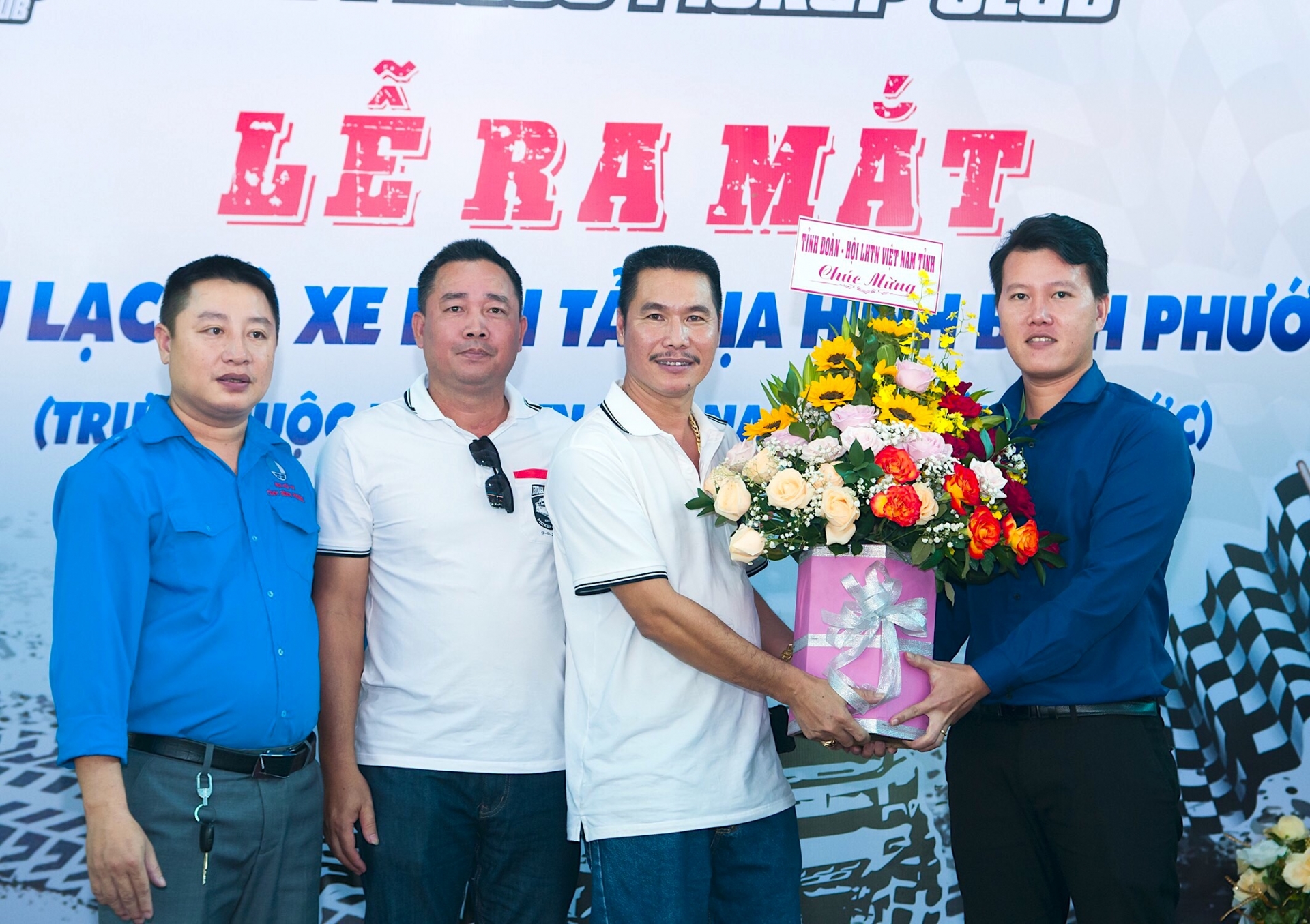 Phó Bí thư Tỉnh Đoàn Trần Hoàng Trực (ngoài cùng, bên phải) cùng Phó Chủ tịch Hội LHTN Việt Nam tỉnh Bình Phước Bùi Xuân Dũng (ngoài cùng, bên trái) trao hoa mừng Lễ ra mắt Bình Phước Pickup cho anh Nguyễn Phúc Tân - Chủ nhiệm CLB (thứ hai, từ phải sang)