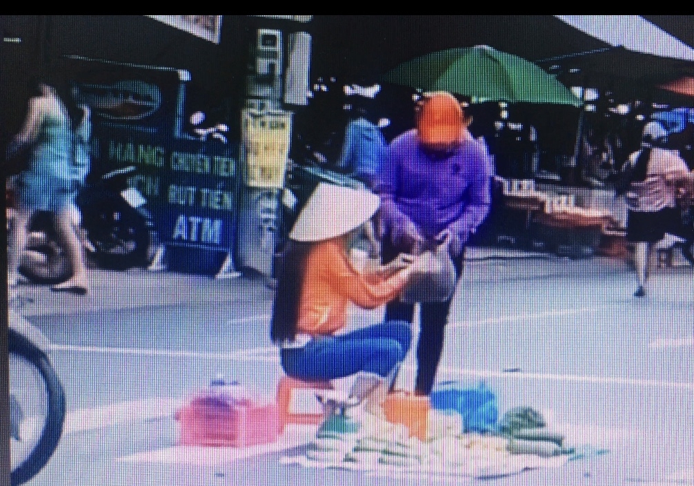 Bất chấp nguy hiểm, người phụ nữ thản nhiên ngồi bán rau giữa lòng đường