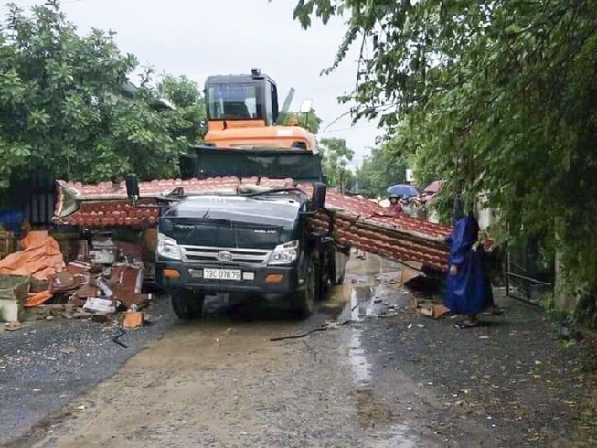 Xe chở máy xúc gạt đổ cổng làng khiến tài xế tử vong