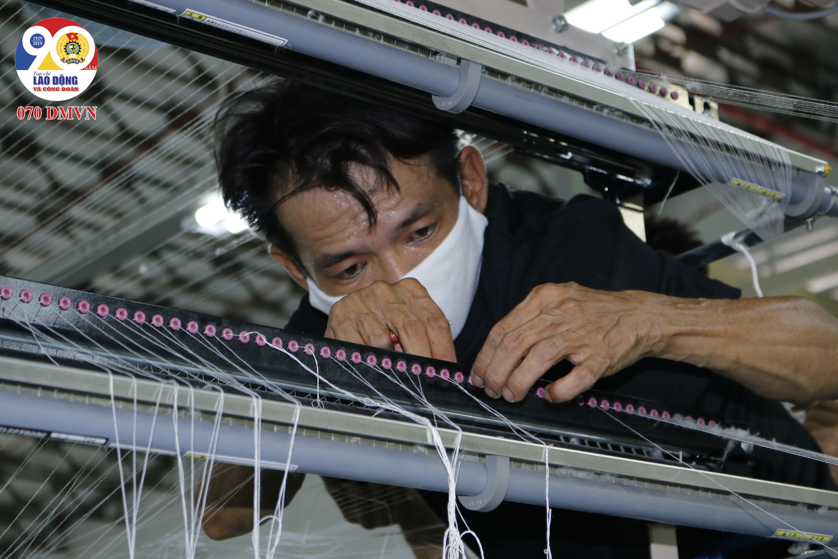 Nam công nhân luồn sợi qua thanh dẫn để đưa sợi vào máy mắc đòi hỏi sự tỉ mỉ chính xác cao
